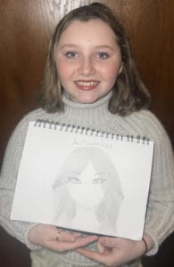 Sarah is holding a piece of her artwork